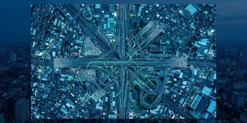 Aerial drone shot of a fractured urban transport network at dusk, with highways and railways forming chaotic patterns, symbolizing fragmented and distorted news information flow. The city glows with cool blue and green lights.
